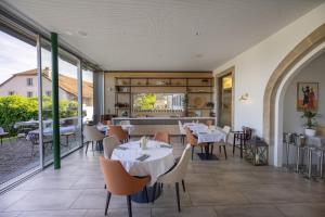 a restaurant with tables and chairs and a large window at Auberge de Confignon in Geneva +16 photos