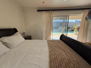 a bedroom with a bed and a view of a pool at Golden Feathers Lodge in Cape Town +39 photos