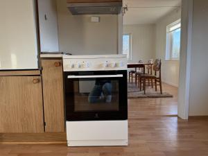 a stove in a kitchen with a dining room at Charming house close to Lekens in Skullbru