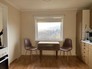 a kitchen with a table and two chairs and a window at Charming house close to Lekens in Skullbru