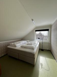 a bedroom with a bed in a room with a window at Charming house close to Lekens in Skullbru