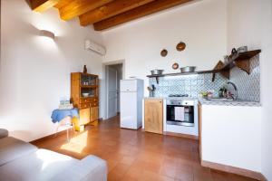a kitchen with a white refrigerator and a stove at Terre e Torri Country Resort in Lascari