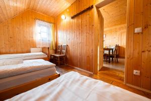 a room with three beds and a table in it at Apartmány Chalupa u Floriánka in Dolní Morava