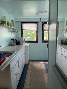 a small kitchen with white cabinets and a window at Casabandow in Schwaan