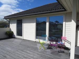 a patio with chairs and a table on a deck at Apartment close to Leknes airport in Leknes