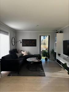 a living room with a black couch and a table at Apartment close to Leknes airport in Leknes