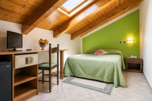 a green bedroom with a bed and a desk at Agriturismo Parmenide in Castelnuovo Cilento