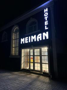 a sign for a merlin store at night at MEIMAN hotel in Aktobe