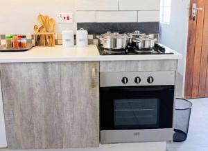 a kitchen with a stove with pots and pans on it at Maun self-catering unit in Maun