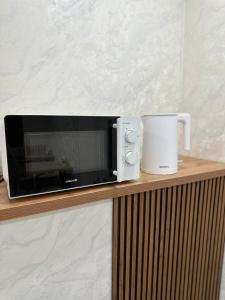 a microwave and a mug on a wooden shelf at MEIMAN hotel in Aktobe +31 photos