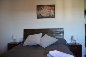 a bed with two night stands and a picture on the wall at Casa Aurora in Teo