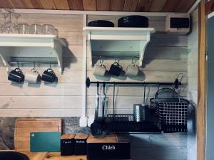 a kitchen with pots and pans hanging on a wall at Domki w Lesie in Silnowo