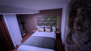 a bedroom with a bed and a stone wall at Casa rural Mirador, Balneario Histórico de Cortegada in Cortegada