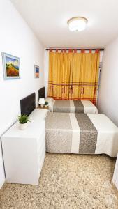 a bedroom with two beds and a window at Vacansis Apartamento Cullera Mar in Cullera