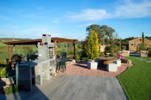 a patio with a grill and a picnic table at Natura-Resort Les Pletes in Palouet