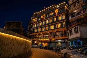 a large building with cars parked in front of it at Hotel Red Rose in Darjeeling