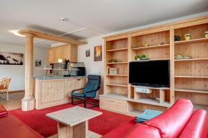 a living room with wooden cabinets and a flat screen tv at Wohnung direkt an der Skipiste in Feldberg