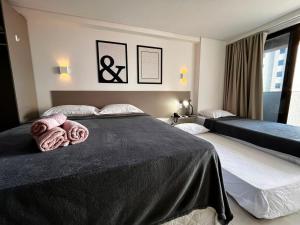 a bedroom with two beds with towels on them at Flat Manaira in João Pessoa