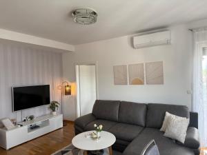a living room with a couch and a tv at Sunset in Teslić