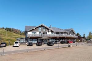 a large building with cars parked in a parking lot at Wohnung direkt an der Skipiste in Feldberg