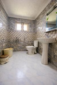 a bathroom with a sink and a toilet and a sink at Lidder view Resort - Best River side resort in Pahalgām