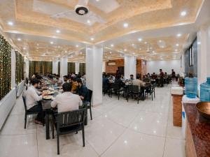 a group of people sitting at tables in a restaurant at Lidder view Resort - Best River side resort in Pahalgām