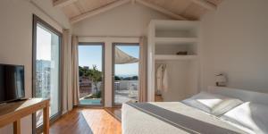 a bedroom with a bed and a large window at Althea Boutique Hotel in Alonnisos
