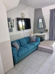 a blue couch in a living room with a tv at Dimitra's House in Vourvourou