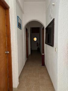 a hallway with an archway and a television on a wall at Pasiphae - Rooms for rent in Agia Galini