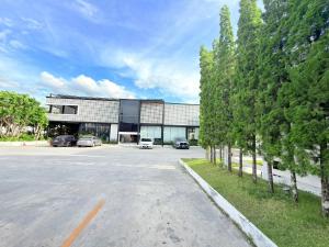 a building with cars parked in a parking lot at The Gold Living Life in Thung Song