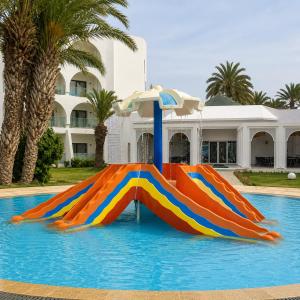 a colorful water slide in the middle of a pool at One Resort Jockey Monastir in Monastir
