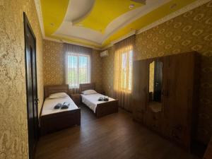 a bedroom with two beds and a yellow ceiling at Terrasa Solar Kutaisi in Kutaisi