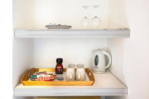 a shelf with a tray with cups and bottles on it at Terre e Torri Country Resort in Lascari