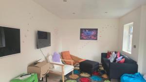 a living room filled with furniture and a flat screen tv at Lion Gardens- The Space in Leyland