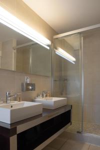 a bathroom with two sinks and a shower at Auberge de Confignon in Geneva