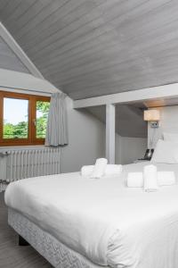 a large white bed in a room with a window at Auberge de Confignon in Geneva