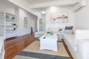 a living room with a white couch and a table at Summer Breeze Lake House in Forster