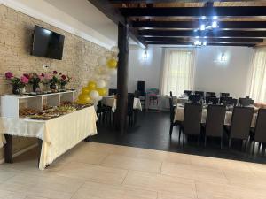 a banquet hall with tables and chairs and a television at La Păstrăvărie ,,Casa Iov,, in Moroeni