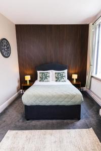 a bedroom with a bed with two tables and two lamps at Mitre Hotel Manchester City Centre in Manchester