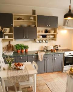 a kitchen with gray cabinets and a table with a bowl of bread at Vabaduse Apartment - külaliskorter Kärdlas in Kärdla +1 photo