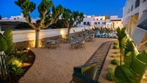 a patio with tables and chairs at night at Hotel S'Algaret in Fornells