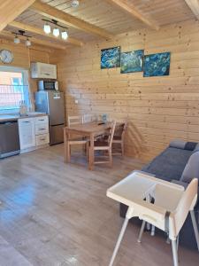 a living room with a table and a kitchen at Morskie Sarbinowo in Sarbinowo