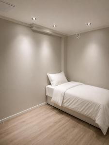 a bedroom with a bed with white sheets at Arya villa in Bergen