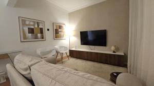 a living room with a couch and a flat screen tv at Odivelas Home in Odivelas