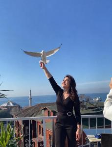 a woman standing on a balcony holding a bird at Ayasofya Hotel - Special Class in Istanbul