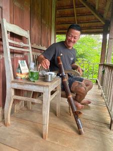 a man sitting next to a table with a baseball bat at Berry homestay 1 in Buon Ma Thuot