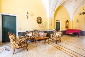a living room with couches and chairs and a table at Palazzo del Borgo Salentino in Acquarica del Capo