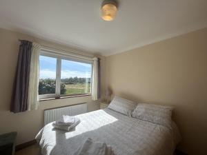 a bedroom with a bed and a window at Waterside Cottage, Cashel in Galway