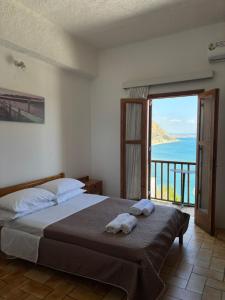 a bedroom with a bed with a view of the ocean at Pasiphae - Rooms for rent in Agia Galini