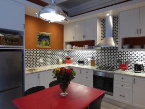 a kitchen with a table with a vase of flowers on it at Romantic Boutique Cottage in upper Hogsback in Hogsback +10 photos